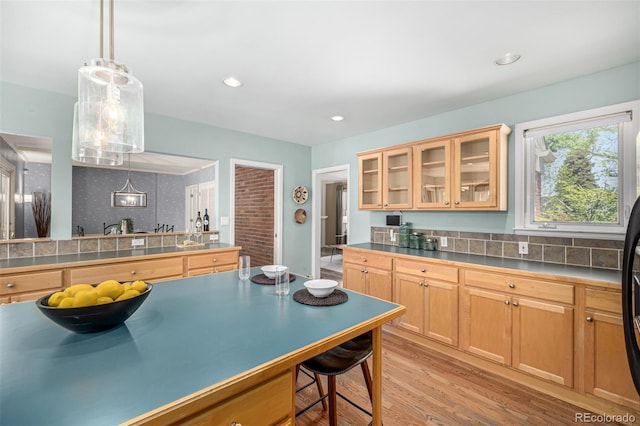 3756 S Forest Way, Denver, CO 80237 - kitchen with a breakfast bar, light wood-style floors, glass insert cabinets, hanging light fixtures, and recessed lighting