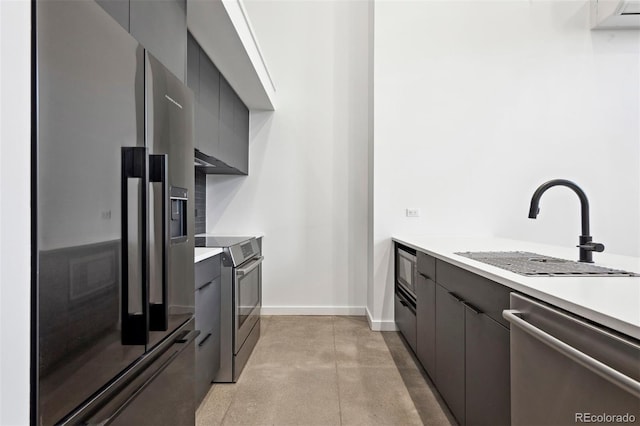 kitchen featuring appliances with stainless steel finishes, gray cabinetry, and sink