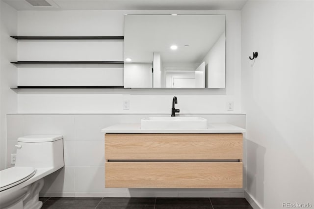 bathroom with tile patterned flooring, vanity, and toilet