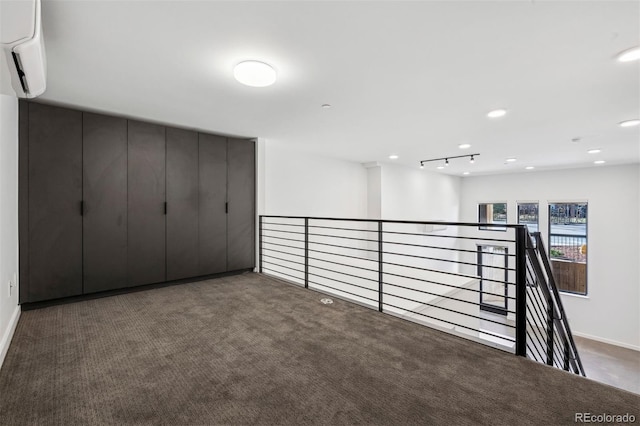 interior space featuring dark carpet and a wall unit AC