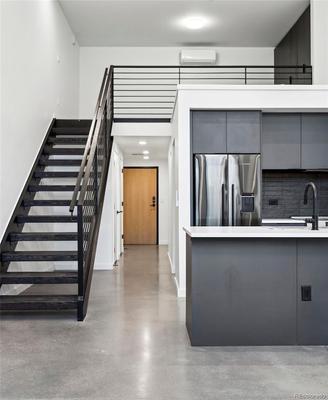 kitchen with stainless steel fridge with ice dispenser, gray cabinets, and sink