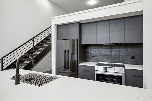 kitchen featuring appliances with stainless steel finishes, backsplash, and gray cabinetry