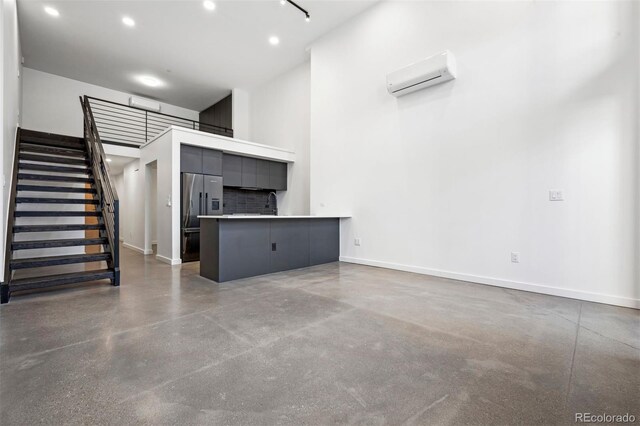 unfurnished living room with an AC wall unit