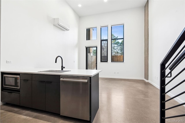 kitchen with an AC wall unit, sink, and appliances with stainless steel finishes