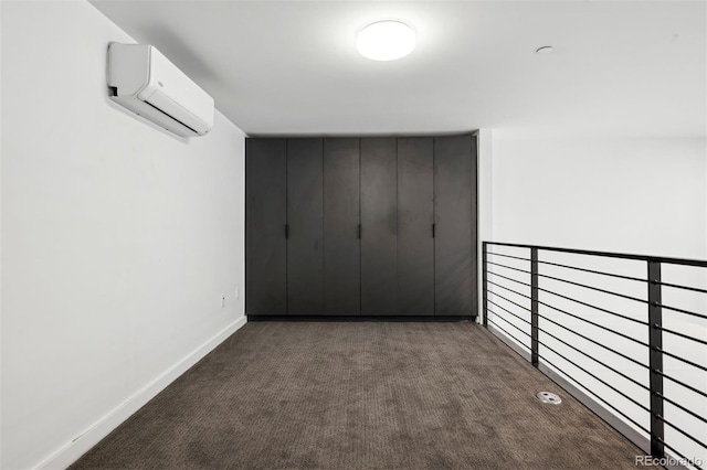 hallway featuring an AC wall unit and dark colored carpet