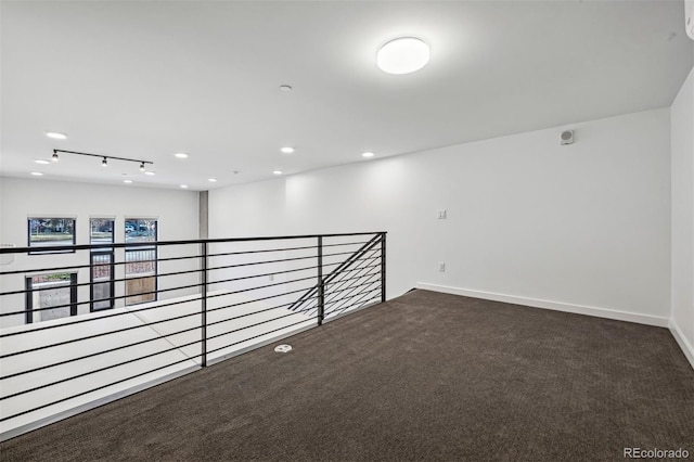 carpeted spare room featuring track lighting