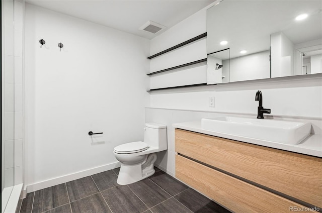 bathroom with vanity, toilet, and a shower