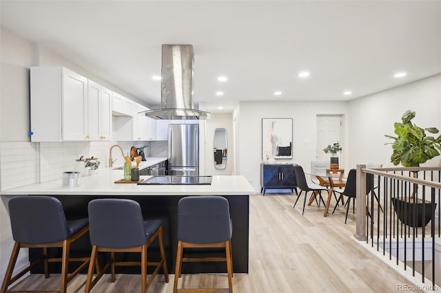 2121 W 33rd Ave, Denver, CO 80211 - kitchen featuring freestanding refrigerator, exhaust hood, light countertops, a peninsula, and tasteful backsplash