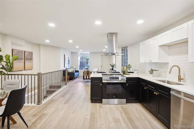2121 W 33rd Ave, Denver, CO 80211 - kitchen with appliances with stainless steel finishes, island exhaust hood, white cabinets, dark cabinetry, and light countertops
