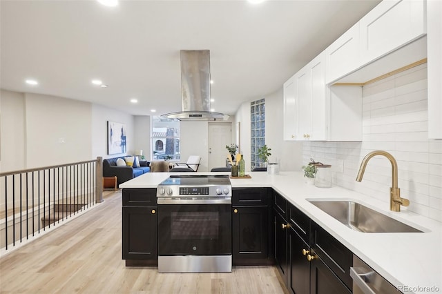 2121 W 33rd Ave, Denver, CO 80211 - kitchen featuring stainless steel appliances, wall chimney range hood, white cabinetry, a peninsula, and open floor plan