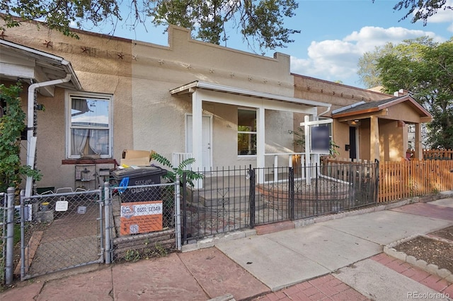 2121 W 33rd Ave, Denver, CO 80211 - view of front of home featuring stucco siding, a fenced front yard, and a gate
