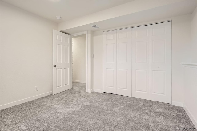 unfurnished bedroom with a closet and light carpet