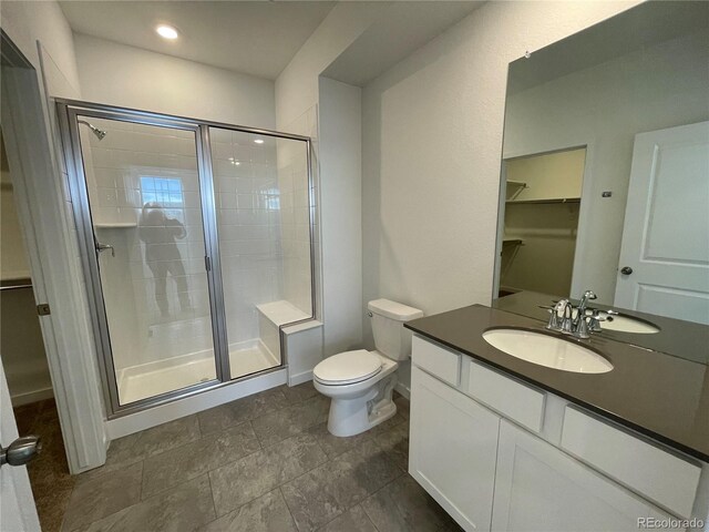 bathroom featuring vanity, toilet, and walk in shower