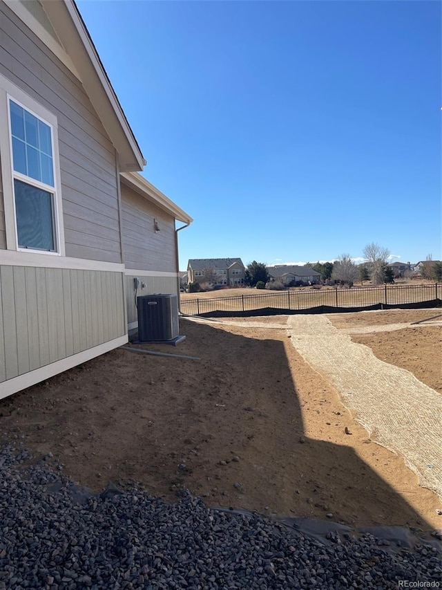 view of yard with fence and central air condition unit