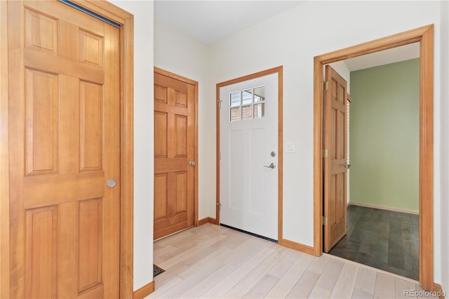 foyer featuring baseboards and light wood-type flooring