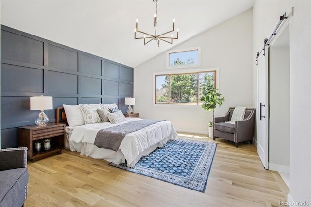 9810 Venneford Ranch Rd, Highlands Ranch, CO 80126 - bedroom featuring a barn door, high vaulted ceiling, a chandelier, a decorative wall, and light wood-style flooring