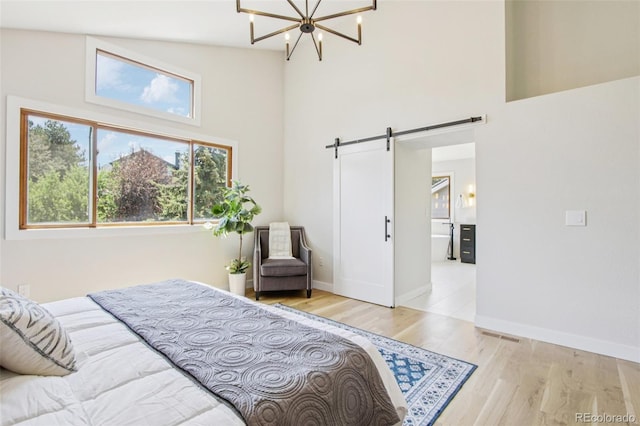 9810 Venneford Ranch Rd, Highlands Ranch, CO 80126 - bedroom featuring high vaulted ceiling, a barn door, wood finished floors, and a chandelier
