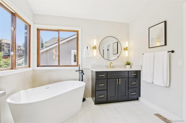 9810 Venneford Ranch Rd, Highlands Ranch, CO 80126 - bathroom with a soaking tub, vanity, healthy amount of natural light, wainscoting, and tile patterned flooring