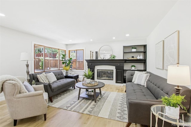 9810 Venneford Ranch Rd, Highlands Ranch, CO 80126 - living room featuring light wood-style floors, a glass covered fireplace, and recessed lighting