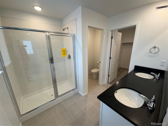 bathroom with an enclosed shower, vanity, tile patterned floors, and toilet