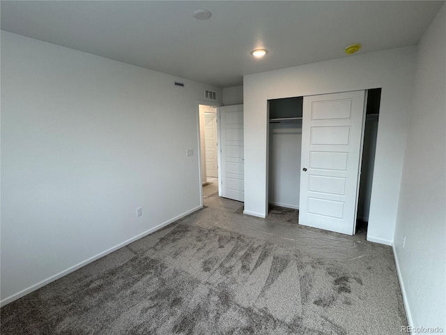 unfurnished bedroom featuring a closet and dark colored carpet