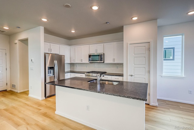 21242 E 63rd Dr, Aurora, CO 80019 - kitchen featuring stainless steel appliances, a sink, light wood-style floors, white cabinets, and backsplash
