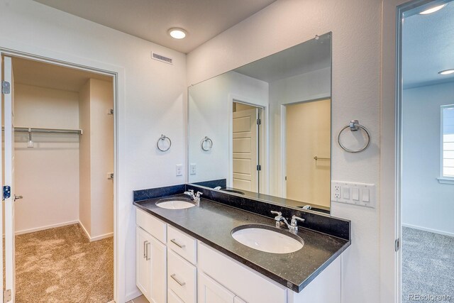 21242 E 63rd Dr, Aurora, CO 80019 - bathroom featuring double vanity, baseboards, and a spacious closet
