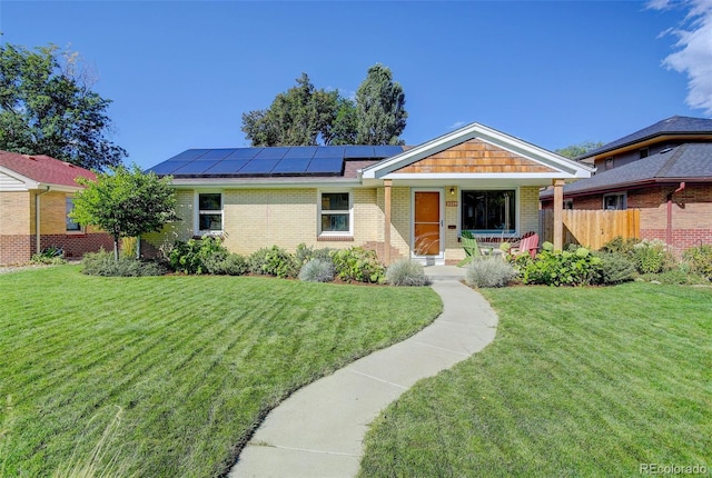 ranch-style home with a front yard and solar panels