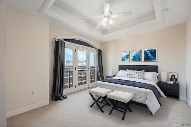 bedroom with ceiling fan, a tray ceiling, access to outside, and carpet flooring