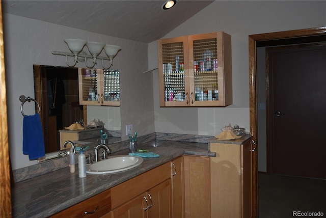 bathroom with lofted ceiling and vanity