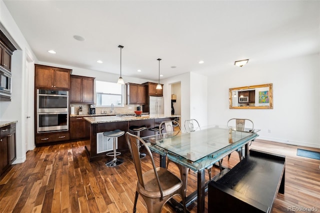 dining space with dark wood-style flooring, recessed lighting, and baseboards