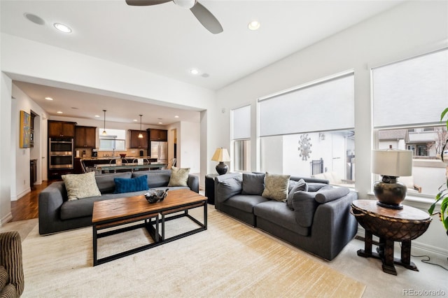 living area featuring baseboards, a ceiling fan, and recessed lighting