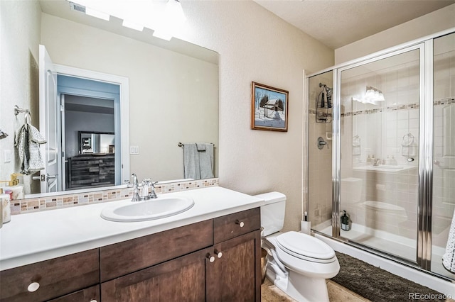 bathroom featuring toilet, a shower stall, visible vents, and vanity