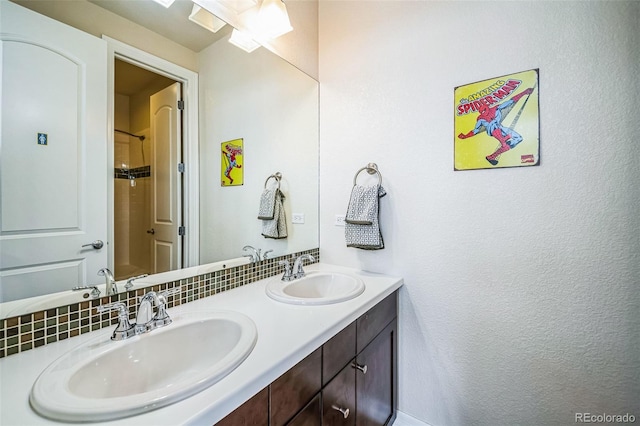 bathroom with a shower, a sink, backsplash, and double vanity