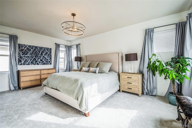 bedroom with a chandelier, light carpet, and baseboards