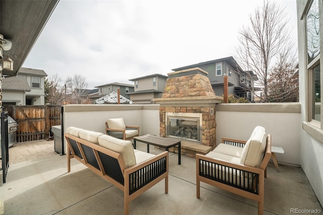 view of patio / terrace with an outdoor living space with a fireplace, area for grilling, and fence