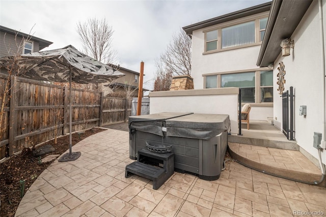 view of patio / terrace with a fenced backyard and a hot tub