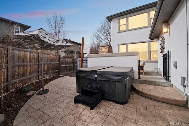 view of patio with a hot tub and a fenced backyard