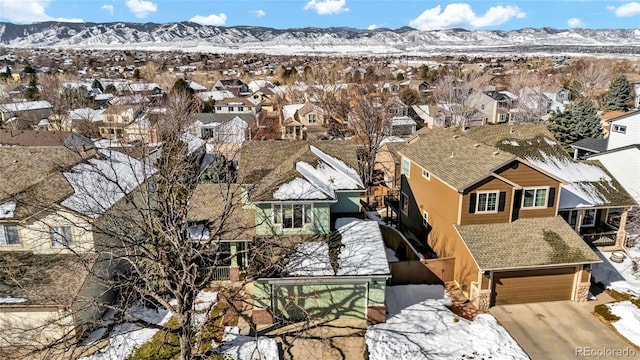 snowy aerial view with a residential view and a mountain view