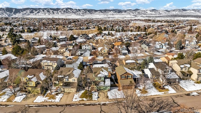 snowy aerial view featuring a residential view and a mountain view