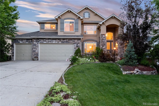 view of front of property with a garage and a lawn