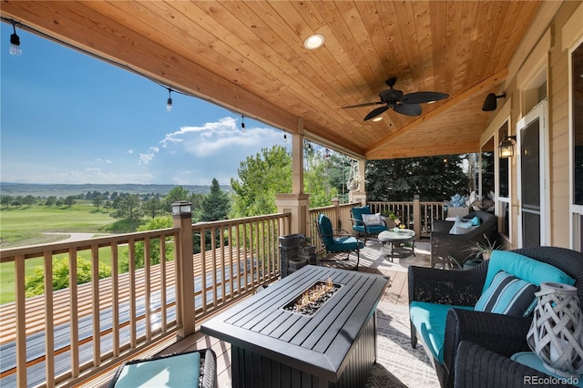 deck with an outdoor living space with a fire pit and ceiling fan