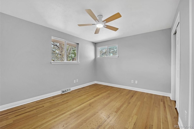 unfurnished bedroom featuring a closet, a ceiling fan, visible vents, light wood finished floors, and baseboards