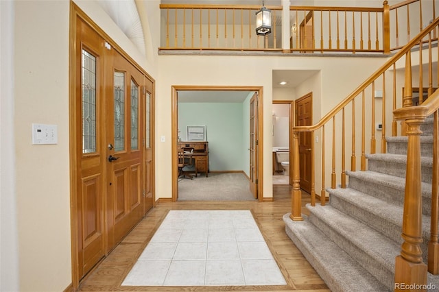 6506 S Robb Way, Littleton, CO 80127 - foyer entrance featuring stairway, light wood-style floors, and a high ceiling