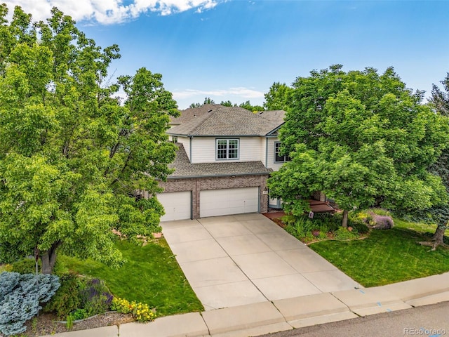 6506 S Robb Way, Littleton, CO 80127 - view of front facade featuring a garage, driveway, brick siding, a front yard, and roof with shingles