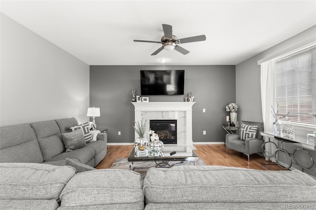24880 E Euclid Pl, Aurora, CO 80016 - living area featuring a premium fireplace, wood finished floors, a ceiling fan, and baseboards