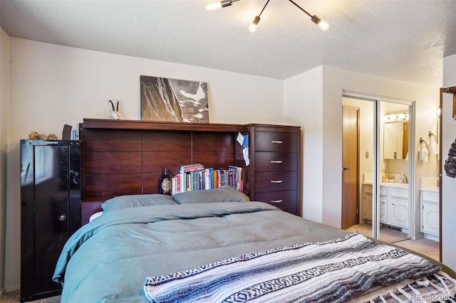 bedroom with connected bathroom, light colored carpet, and a closet