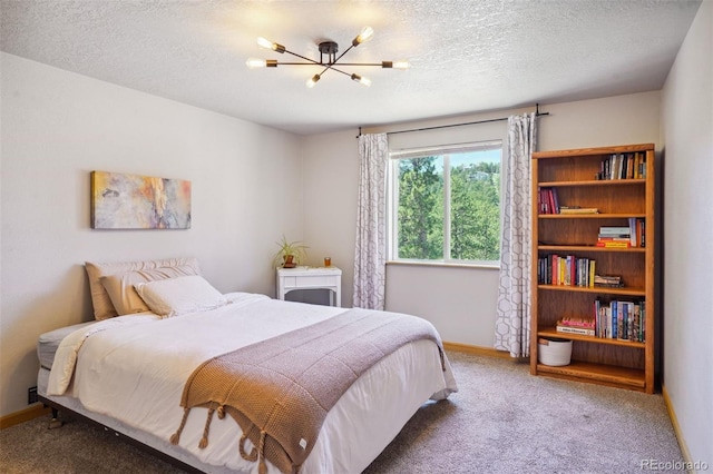 carpeted bedroom with a chandelier and a textured ceiling