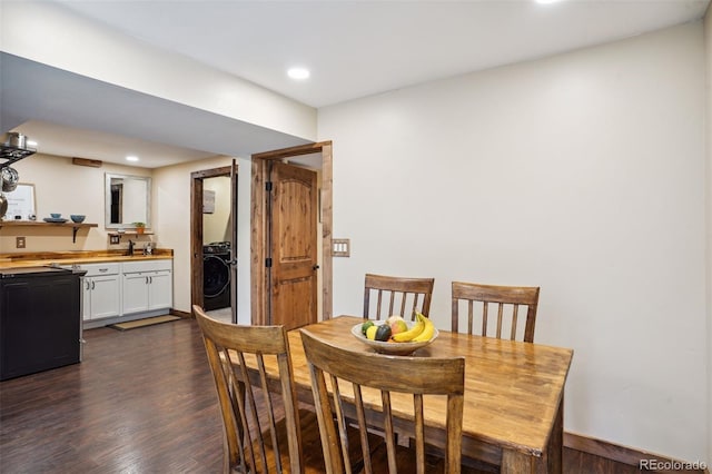 dining area with sink, washer / dryer, and dark wood-type flooring