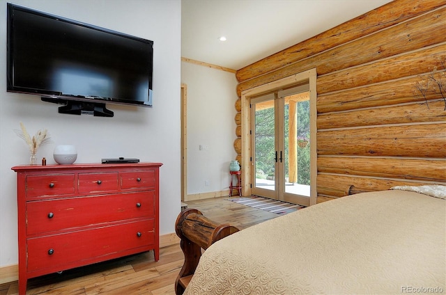 bedroom featuring light wood-type flooring, french doors, access to outside, and log walls